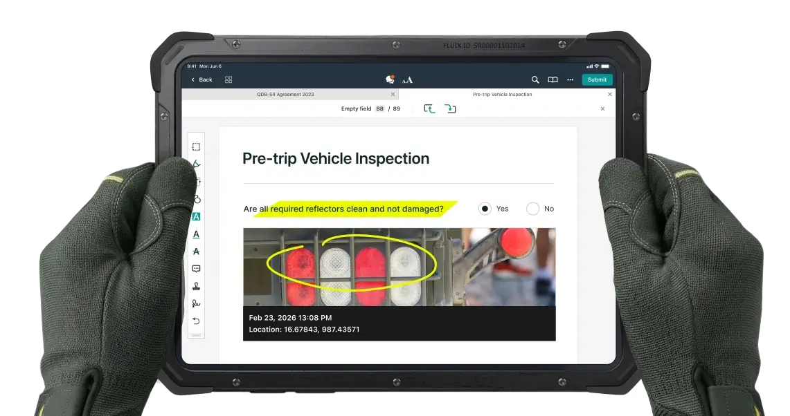 Close up of a technician holding tablet with a preview of pre-trip vehicle inspection checklist in vehicle inspection software