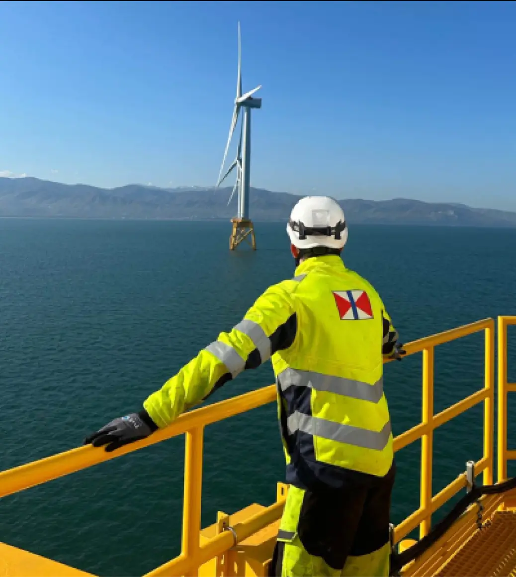 A Swire Energy engineer inspects a wind turbine on an offshore platform