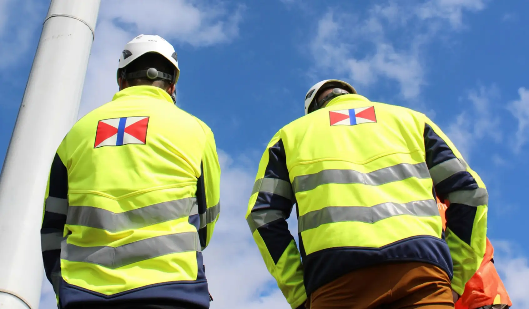 Swire Energy Technicians Next to the Wind Turbine