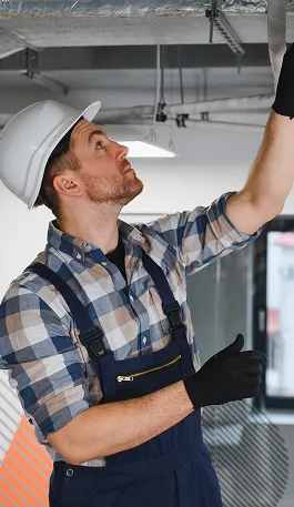 HVAC technician working on air conditioning and ventilation pipes