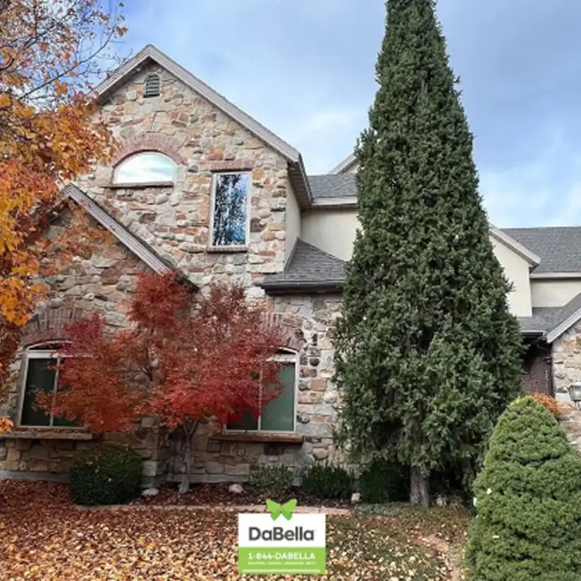 A brick mansion in autumn, with a lawn covered in fallen leaves. The image labelled by DaBella logo.