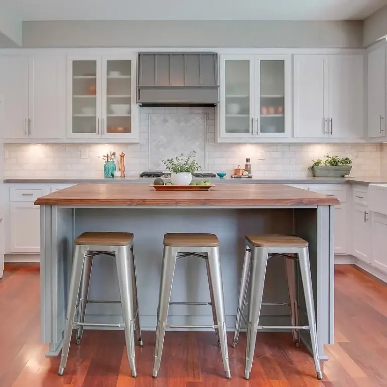 A kitchen with a table and three chairs
