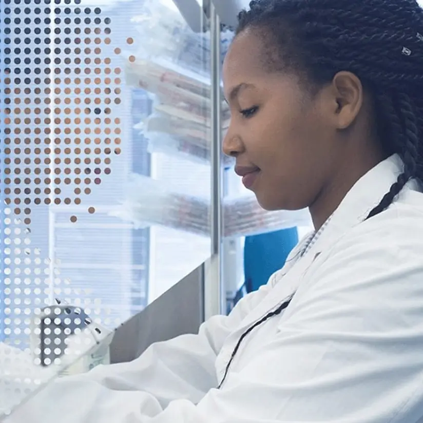 A female laboratory technician in a white coat at work.