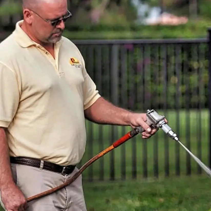 Petri worker using a hose on the lawn.
