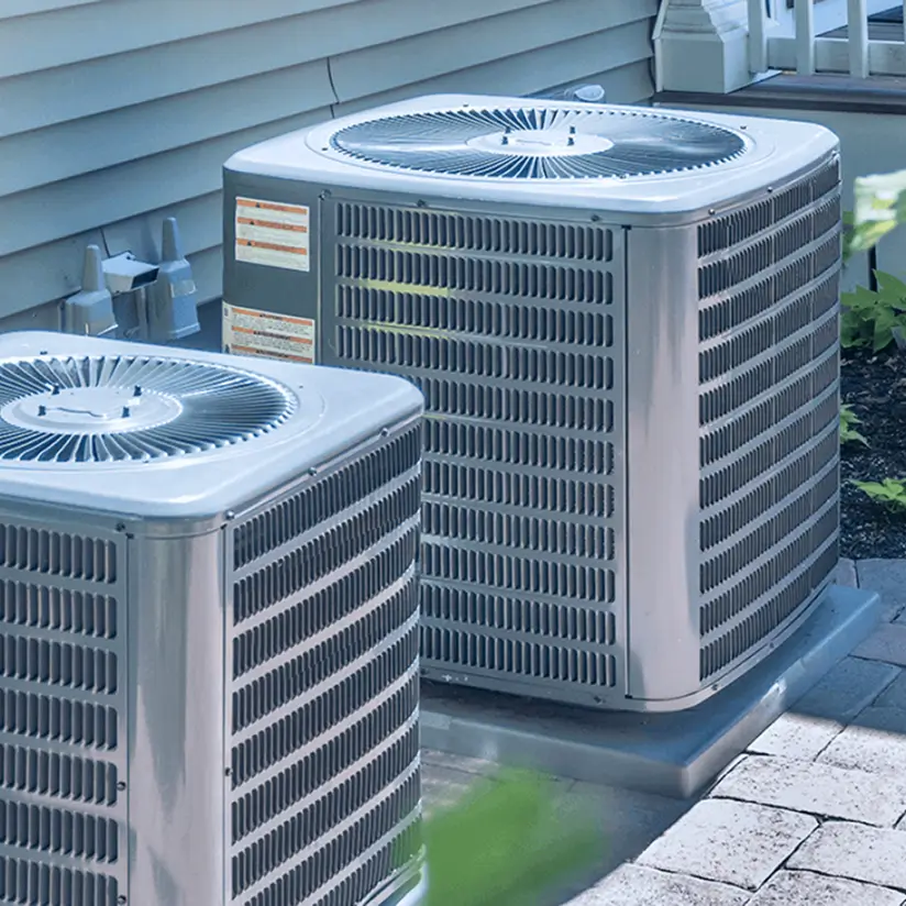 Two HVAC units near a building.