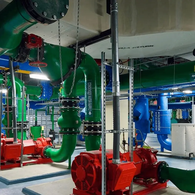 A workshop with red engines and green pipes connected to them.
